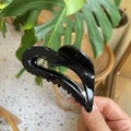 Detail of a black heart-shaped acetate hair claw clip with golden Barrette La France text - Heart / Black