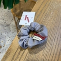 Chouchou élégant à rayures grises avec nœud rouge sur une surface en bois naturel - Chouchou Noeud Gris / Gris