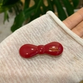 Eleganter roter handgefertigter Azetat-Haarclip mit Goldlogo auf weißem Stoff - Rot