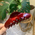 Dettaglio del fermaglio per capelli bordeaux in acetato con scritta dorata lucida - Nuvola a Denti Tondi Obliqui