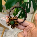 Detailed view of a leopard print flower hair tie with rhinestones and a green bead accent - Green Bead Leopard Flower Rhinestone Hair Tie
