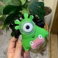 Detail of green leather monster hair scrunchie with oversized eye and pink lips design - Green One-Eyed Monster