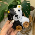 Détail d'un charm ours en cuir fait main noir et blanc avec yeux boutons jaunes et roues bois - Ours Noir et Blanc