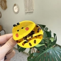 Detailed close-up of a cute cartoon bee hair claw clip made of yellow and tortoise acetate - Bee