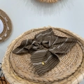 Brown striped oversized scrunchie with a gold heart charm on a woven natural tray - Striped Scarf Style / Coffee
