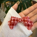 Elegant red plaid bow hair clip in hollow acetate resin, shown held by a hand - Red Lace Duckbill Clip (7cm)