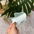 Detail of a pearlescent light blue fish-shaped acrylic hair claw with cute white line patterns - Mint Green Fish
