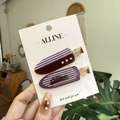 Detalle de dos pinzas para el cabello a cuadros con pedrería en rojo oscuro y lila - Pinza Sin Rastro Morado Uva con Strass