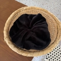 Plush black velvet scrunchie in a woven basket with a cozy autumnal aesthetic - Black