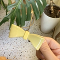 Detail shot of a minimalist light yellow bow hair clip with smooth glossy finish - Yellow