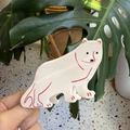 Détail de la pince à cheveux ours polaire en acétate blanc avec des accents rouges brillants - Chien de Montagne des Pyrénées