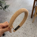 Detalle de la etiqueta tejida a mano en una diadema de felpa marrón suave para el invierno - Caqui