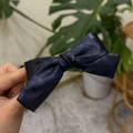 Detail of blue faux leather hair scrunchie with jacquard bow texture and hand-held view - Bow Hair Clip (PU Leather Texture) / Navy Blue