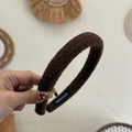Détail d'un serre-tête en peluche marron avec étiquette faite main et texture - Café