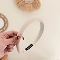 Thick cream fabric sponge headband with handmade label shown in a lifestyle setting - Off White