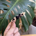 Gros plan sur une pince à cheveux en acétate écaille avec inscription dorée France Handmade - Écaille Claire