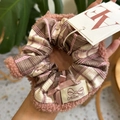 Dettaglio di elastico in pile rosa con tessuto a scacchi e fiocco di raso - Teddy Fur Pink Bow Scrunchie