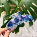 Grosse pince à cheveux en acétate avec texture marbrée irisée bleu et violet en gros plan - Bleu Foncé AB