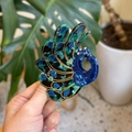 Detail of peacock acetate hair claw clip with golden outlines and crystal accents - Blue Green Peacock