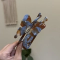 Detailed close-up of butterfly hair claw clip with blue and brown marbled texture - Blue Brown Marble