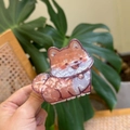 Vista dettagliata della molletta per capelli Shiba Inu con finitura perlata in acetato - Cane arancione in piedi sorridente con campanello
