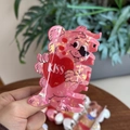Macro shot of pink acrylic hair claw clip featuring a cartoon bear and Kiss heart design - Pink Heart Kiss Bear
