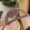 Detailed view of large mauve semi-circle hair claw clip with smooth glossy finish - 10cm / Transparent Brown