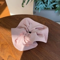 Pink checkered scrunchie made of waffle fabric on a wooden background for women - Pink
