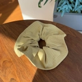 Pale yellow checkered canvas scrunchie on wooden desk with elegant sunlight and shadows - Avocado Green