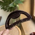 Detail of dark brown semi-circular hair claw clip with glossy finish and dense comb teeth - 10cm / Chocolate
