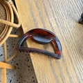 Detail showing the tortoiseshell pattern and hollow semi-circle design of the large hair claw - Matte Red Brown