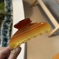 Detail of a large gradient amber acetate hair claw clip with a shimmering pearlescent finish - Caramel-Transparent Yellow Gradient