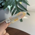 Detailed macro view of pink and yellow marble acrylic hair clip with silver metal base - Spring Color