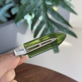 Close-up of a translucent green resin hair clip with a silver metal base in hand - Transparent Emerald Green