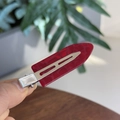 Detail shot of a red acrylic hair clip with crocodile texture and silver metal base - Ancorra Red