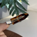 Close-up of tortoise shell resin hair clip with silver metal base held in hand - Dark Tortoiseshell