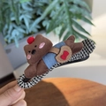 Détail d'une pince à cheveux petit chien en velours marron avec motifs à carreaux - Chien Marron Allongé Pince