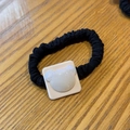 Close-up of a white pearlescent bear ornament on a black pleated elastic hair scrunchie - Pearl White Bear Hair Tie