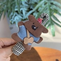 Gros plan d'une pince à cheveux petit chien en velours côtelé avec base en tissu à carreaux - Chien Marron Debout Pince