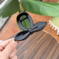 Detail of matte black bow hair claw clip showing textured finish and spring mechanism - Matte Black