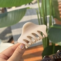 Detailed view of cream beige hair claw clip with smooth resin finish and shark tooth design - Light Nude Pink