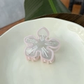 Pince à cheveux fleur en acétate rose avec strass sur un plateau de présentation - Rose Sakura