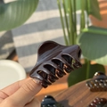 Detailed view of a small 6cm dark brown butterfly hair claw clip with glossy finish - Chocolate