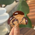Détail d'une pince à cheveux champignon en acétate de cellulose marron à texture marbrée - Quatre Noix