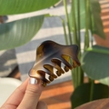 Detailed view of an amber gradient hair claw clip with a glossy translucent finish - Matte Tortoiseshell