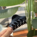 Glossy black butterfly claw clip with 6cm keel design held against an outdoor background - Glossy Black