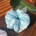 Scrunchie a quadretti blu chiaro con bottone rosa su elegante fondo in legno scuro - Bottone Rosa Blu Verde Rosa A Quadri