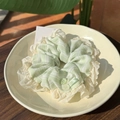 Fresh striped scrunchie with ruffled edges and green buttons on a cream plate - Green and White Striped