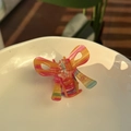 Detail of a translucent butterfly hair claw with colorful iridescent stripes on white ceramic - Approx 6.8cm / Rainbow