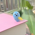 Vue détaillée d'une mini pince à cheveux hibou bleue avec motifs dorés sur un livre - Bleu Océan avec Ailes Jaunes